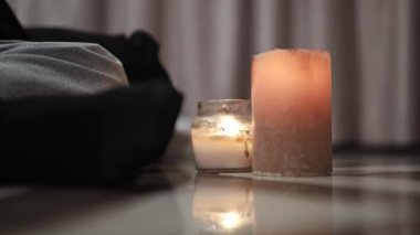 Rahat kadın evde aromatik mumlarla rahat bir akşam geçirir. Günlük giysiler içinde dinleniyor, huzur, huzur ve rahatlık yaşıyor..
