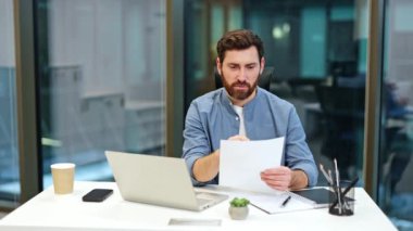 Sakallı heyecanlı iş adamı ofiste iyi haberler alıyor. Mutlu erkek başarıyı kutlar, ellerini kaldırır, ve güler, sevinçlerini ifade eder..