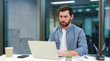 Hüsrana uğramış iş adamı laptoptaki çığlıkları ve kulakları kapatıyor. Genç erkek, modern ofiste stres ve başarısızlık yaşıyor. Son teslim tarihi, tükeniş.