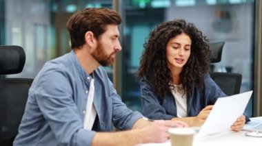 Kendinden emin kıvırcık iş kadını, erkek meslektaşıyla belgeyi gözden geçirir ve modern bir ofiste başarılı bir şekilde anlaştıktan sonra el sıkışır..