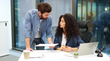 Odaklanmış meslektaşlarım modern ofiste bir belgeyi tartışıyorlar. İş kadını ve işadamı proje üzerinde birlikte çalışıyorlar. Meşgul profesyonel iş adamı şirket çalışanı, genç bayan işçi yazılım geliştiricisi.