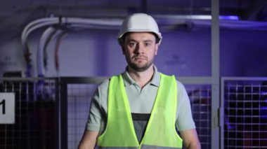 Sunucu odasında kolları çapraz olan ciddi bir elektrik mühendisi. Üniformalı kendinden emin erkek teknisyen elektrik santralinin önünde duruyor. Kontrol panelinde çalışan profesyonel elektrikçi..