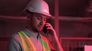 Kasketli ve güvenlik yelekli ciddi bir adam karanlık sunucu odasında yardım istiyor. Kırmızı alarm ışığı yanıp sönüyor. Sistem hatası, tehlike.