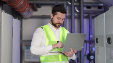 Kazan dairesinde dizüstü bilgisayar kullanan endüstriyel havalandırma mühendisi. Isıtma sistemi ekipman odasında bilgisayar konusunda profesyonel mekanik sistem uzmanı.