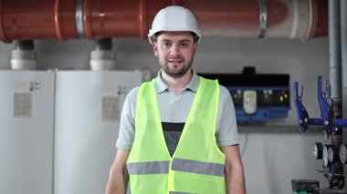 Kendine güvenen erkek mühendis kazan dairesinde elinde ingiliz anahtarı, çalışmaya hazır bekliyor. Endüstriyel iş geçmişi.