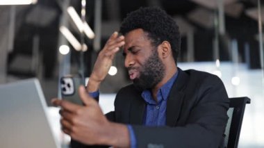 Modern ofiste çalışırken teknolojiyle ilgili sıkıntıları olan sinirli bir işadamı. Sakallı adam telefonu tutar ve sıkıntı içinde alnını ovar..