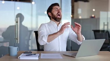 Modern ofis masasına hapşırıp esneyen yorgun işadamı. Yorgun erkek işçi kendini kötü hissediyor, mevsimsel alerji ya da grip geçiriyor..