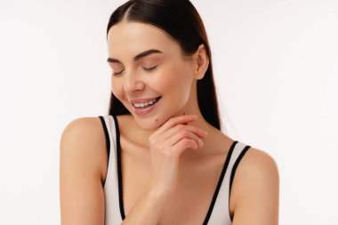 Doğal ışıklandırmada gülümseyen bir bireyin parlak ve neşeli görüntüsü, pozitifliği ve zarafeti teşvik ediyor..