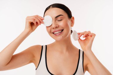 Kişi, elinde pamuk tutarken cilt bakımı rutini gösterir. Parlak ve neşeli bir atmosferle temiz ve ferahlatıcı anları yakalar..