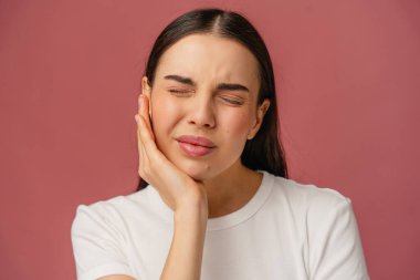 Sıkıntılı bir yüz ifadesi olan kişi yanağa dokunur, bu da rahatsızlık ya da diş ağrısını gösterir..