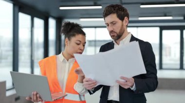 Başarılı ekip modern ofisin planlarını tartışıyor. Profesyonel yatırımcı ve mimar birlikte çalışıyorlar..