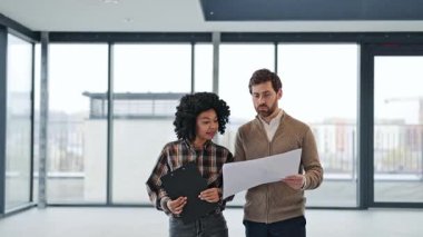 Profesyonel meslektaşlar modern ofis alanının planlarını tartışırlar. Coşkulu ve motive olmuş hissediyorlar. Ticari gayrimenkul yatırımlarında uluslararası işbirliği anlaşması.