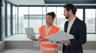 Profesyonel mimar ve yatırımcı modern ofiste planları tartışıyor. Yeni bir proje planlarken odaklanmış ve kararlı hissediyorlar..