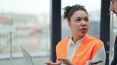 Profesyonel mühendis ve yatırımcı modern bir ofiste bir projeyi tartıştılar. Mühendis planı açıklarken yatırımcı notlar alır. Takım çalışması, başarı ve yenilik anahtardır..