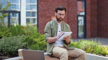 Dışarıda çalışmakla meşgul bir işadamı. Defterde başarılı bir serbest yazar. Ofis binasının yanındaki bankta oturan bir erkek uzman. Sıradan giyinen adam işten zevk alıyor..