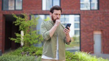 Telefonu kullanırken öksüren yakışıklı bir adam. Sıradan giyinmiş sakallı adam dışarıda kendini iyi hissetmiyor. Hüsrana uğramış erkek kötü haber alıyor..