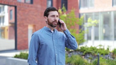 Gündelik giysiler içinde yakışıklı bir iş adamı şehirde telefonla konuşuyor. Başarılı yatırımcı anlaşmayı tartışıyor. Olumlu duygular yaşayan profesyonel bir uzman..
