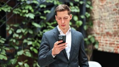 Ofiste telefon kullanan takım elbiseli yakışıklı bir iş adamı. Profesyonel yatırımcı internette haberleri kontrol ediyor. Uzman, akıllı telefondan şok edici haberler okuyor..