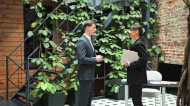 Modern bir ofiste verimli bir toplantının ardından başarılı iş adamları el sıkışıyor. İş yerinde neşe ve mutluluk.