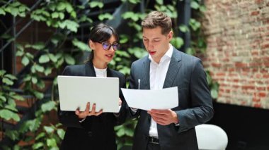 Başarılı bir iş kadını ve işadamı belgeleri tartışıyor. Modern ofiste çalışan odaklanmış girişimciler. Takım çalışması, liderlik..