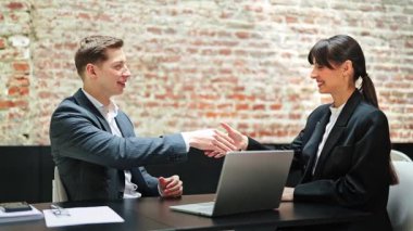 Başarılı iş adamı ve iş kadını modern ofiste el sıkışıyor. Resmi olarak mutlu iş arkadaşları iş yerinde anlaşma yaparken giyerler. Eğlence, anlaşma, başarı.