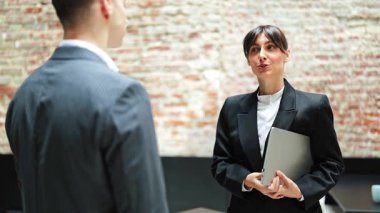 Kendine güvenen iş kadını ve işadamı, modern ofiste başarılı bir şekilde buluştuktan sonra el sıkışıyor. Resmi giyinmiş ofis çalışanları.