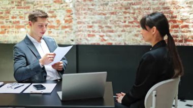 Başarılı iş adamı ve resmi giyinmiş iş kadını modern ofiste bir projeyi tartışıyor. Pozitif duygular, ortaklık ve takım çalışması.