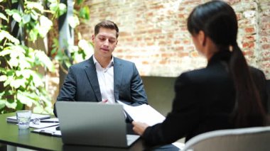 Başarılı bir iş adamı ve iş kadını bir iş toplantısında belgeleri tartışırlar. Resmi görevdeki hevesli ofis çalışanları modern bir ofiste çalışırlar..