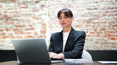 Takım elbiseli stresli iş kadınının boğazı ağrıyor, dizüstü bilgisayarla çalışıyor. İş kadını büro masasında oturuyor, sağlıksız ve boğazında rahatsızlık hissediyor..