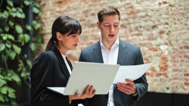 Başarılı bir iş kadını ve işadamı modern bir ofis binasında bir projeyi tartışıyor. İş ortakları birlikte çalışıyor..