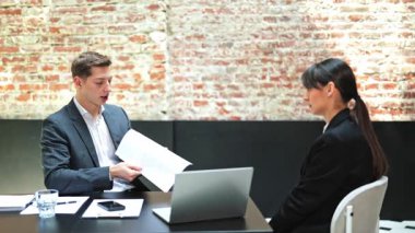 Başarılı iş adamı ve iş kadını ofiste belgeleri tartışırlar. Resmi giyinmiş iş ortaklarının toplantısı var. Takım çalışması ve işbirliği.