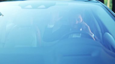 Takım elbiseli kızgın işadamı hayal kırıklığından heyecana kadar değişen duygular yaşıyor ve park halindeki arabasının içinde önemli bir telefon görüşmesi yapıyor. Yoğun bir konuşma dinamik bir iş kararını yansıtır