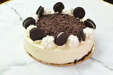 Üzerinde beyaz krema ve çikolata parçacıkları olan lezzetli bir tatlı. Pasta beyaz krema ve çikolata parçacıklarıyla süslenerek, neşeli ve hoşgörülü bir görünüm kazandırılıyor.