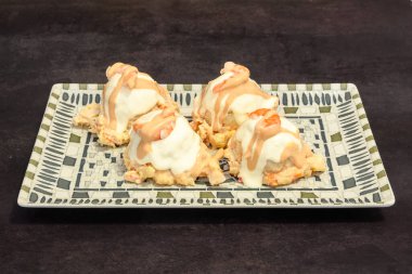 Beyaz soslu dört küçük tatlı tabağı. Tatlılar siyah arkaplanda kare şeklinde düzenlenir.