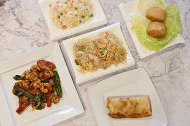 Karides tabağı ve rulo ile bir tabak yemek. Tabak beyaz ve yemek renkli.