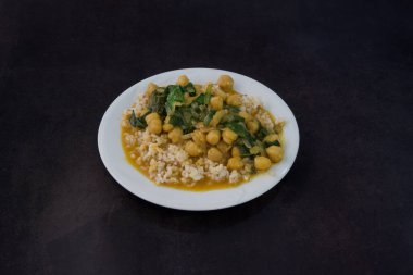 Pirinçli ve nohutlu bir tabak yemek. Tabak beyaz ve yemek renkli.