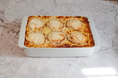 İçinde altı parça yiyecek olan beyaz bir tabak. Yemekler sarı ve altın kabuklu.