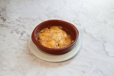 Üstünde fındık olan bir kase yemek. Beyaz bir tabakta.