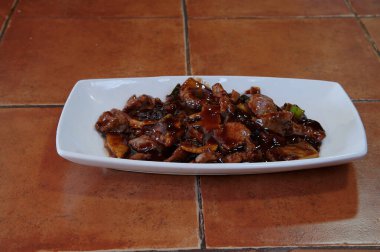 Masada soslu bir tabak et. Sos kahverengi, et kahverengi.