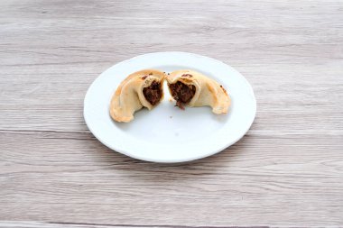 İki etli börek tabağı. Birinin yarısı yenmiş.