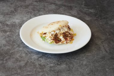 Üstünde burrito olan bir tabak. Tabak beyaz.