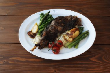 Et, sebze ve patatesli bir tabak yemek. Et tam bir tavuk. Sebzeler arasında brokoli, kuşkonmaz ve domates var. Patatesler küp şeklinde kesilmiş.