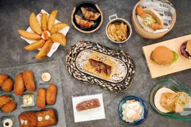 İçinde bir sandviç, bir kase salata ve bir tabak patates olan bir masa.