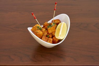 Limon dilimli bir kase yemek. Kase beyaz, yemek turuncu.