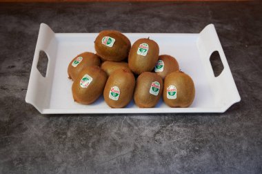 Bir tepsi yeşil kivi meyvesi. Onlardan dokuz tane var. Hepsi aynı boyda.