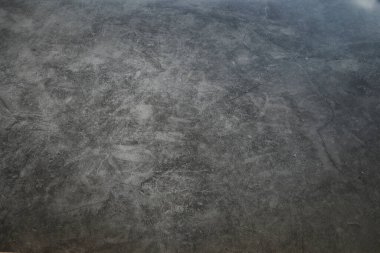 Üzerinde birkaç çizik olan gri bir duvar. Duvar betondan yapılmış. Çizikler farklı boyutlarda ve şekillerde.