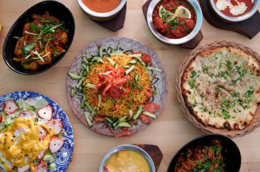 İçinde salata, bir tabak pilav ve bir kase çorba olan bir masa.