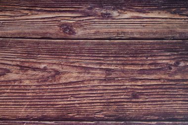 Tahta bir yüzey ve kumlu bir doku. Ahşap kahverengidir ve pürüzlü bir görünüşü vardır. Yüzey pürüzlü ve bazı gözle görülür kusurları var.