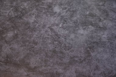 Birkaç çizik olan gri ve siyah bir zemin. Zemin betondan yapılmış. Görünürde insan ya da nesne yok