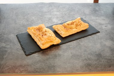 Siyah tabakta iki hamur işi. Biri solda ve diğeri sağda.